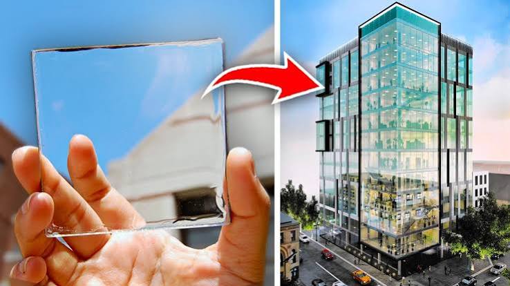 Modern glass building with transparent solar panels integrated into its windows, generating clean renewable energy while allowing natural sunlight to pass through.